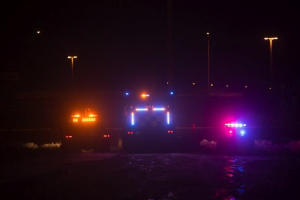 Tow truck, snow plow, and police car at night
